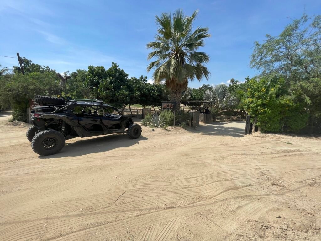 Small group beside a Can-Am Maverick X3 at sunset after a tour starting from Acre Restaurant, San José del Cabo